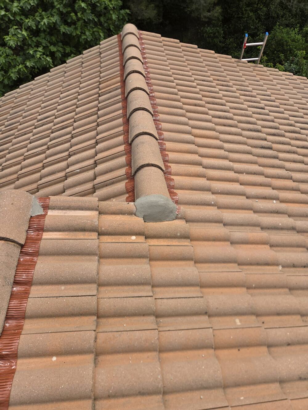 Détail d'étanchéité et de gouttière sur une toiture en tuiles